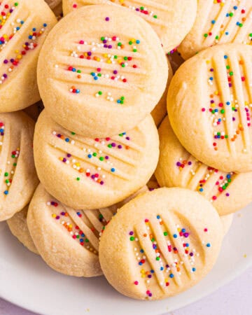 Whipped Shortbread Cookies with sprinkles - on a white plate.