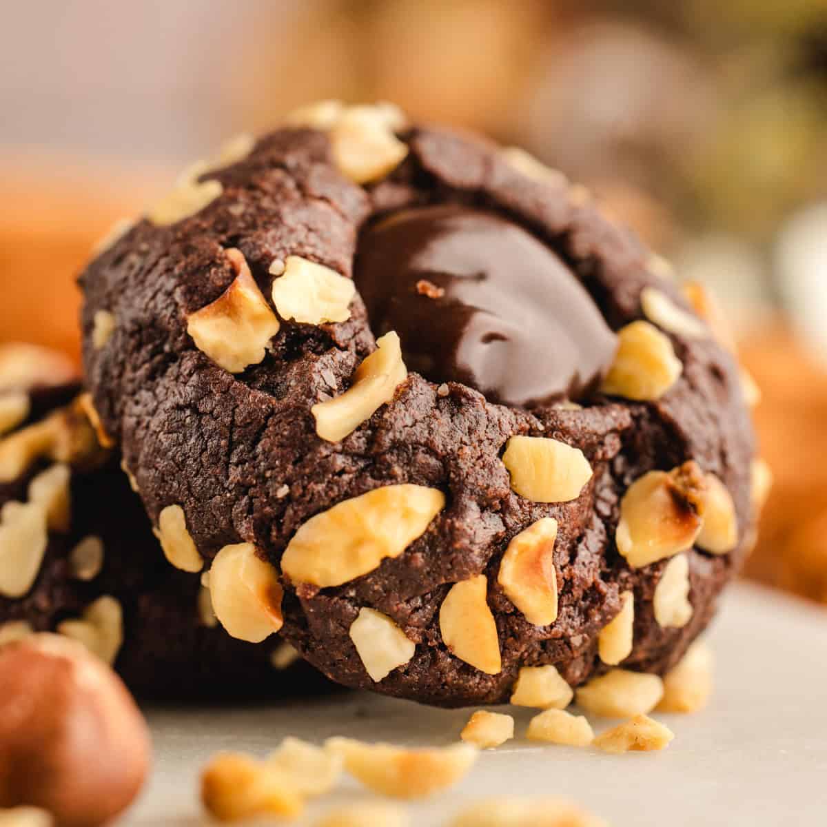 Chocolate Hazelnut Thumbprint Cookies Chocolate Hazelnut Thumbprint Cookie on a white surface.