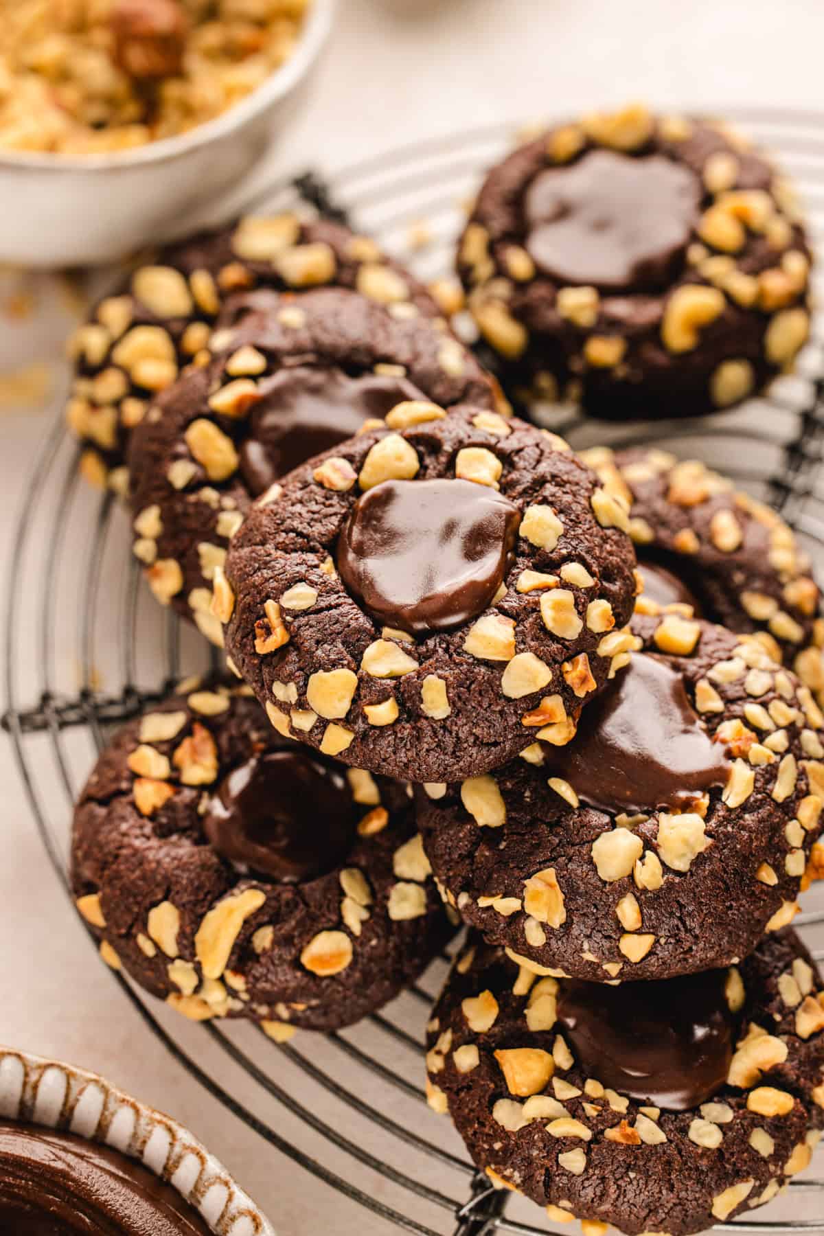 Chocolate Hazelnut Thumbprint Cookies Chocolate Hazelnut Thumbprint Cookies piled up on a rack.
