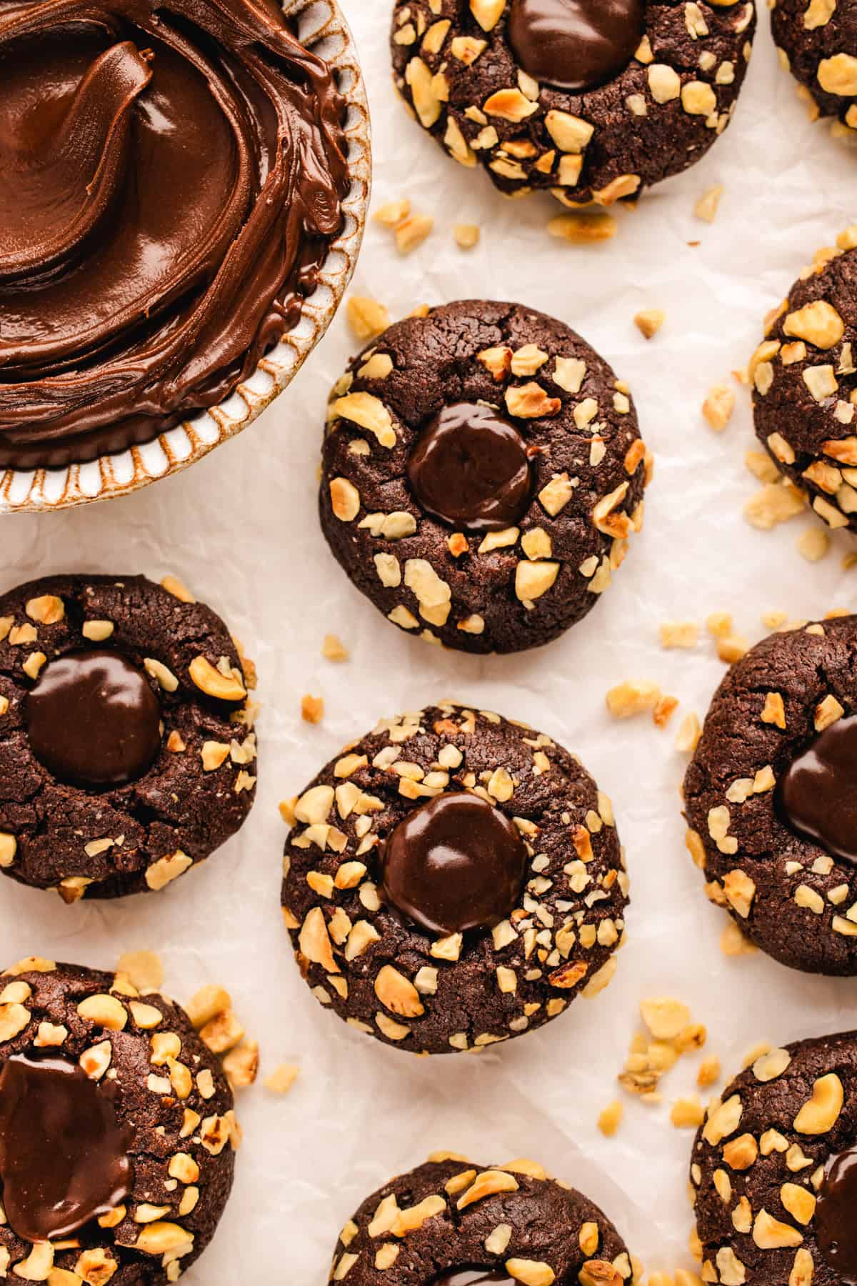 Chocolate Hazelnut Thumbprint Cookies Chocolate Hazelnut Thumbprint Cookies with a bowl of Nutella on a white background.