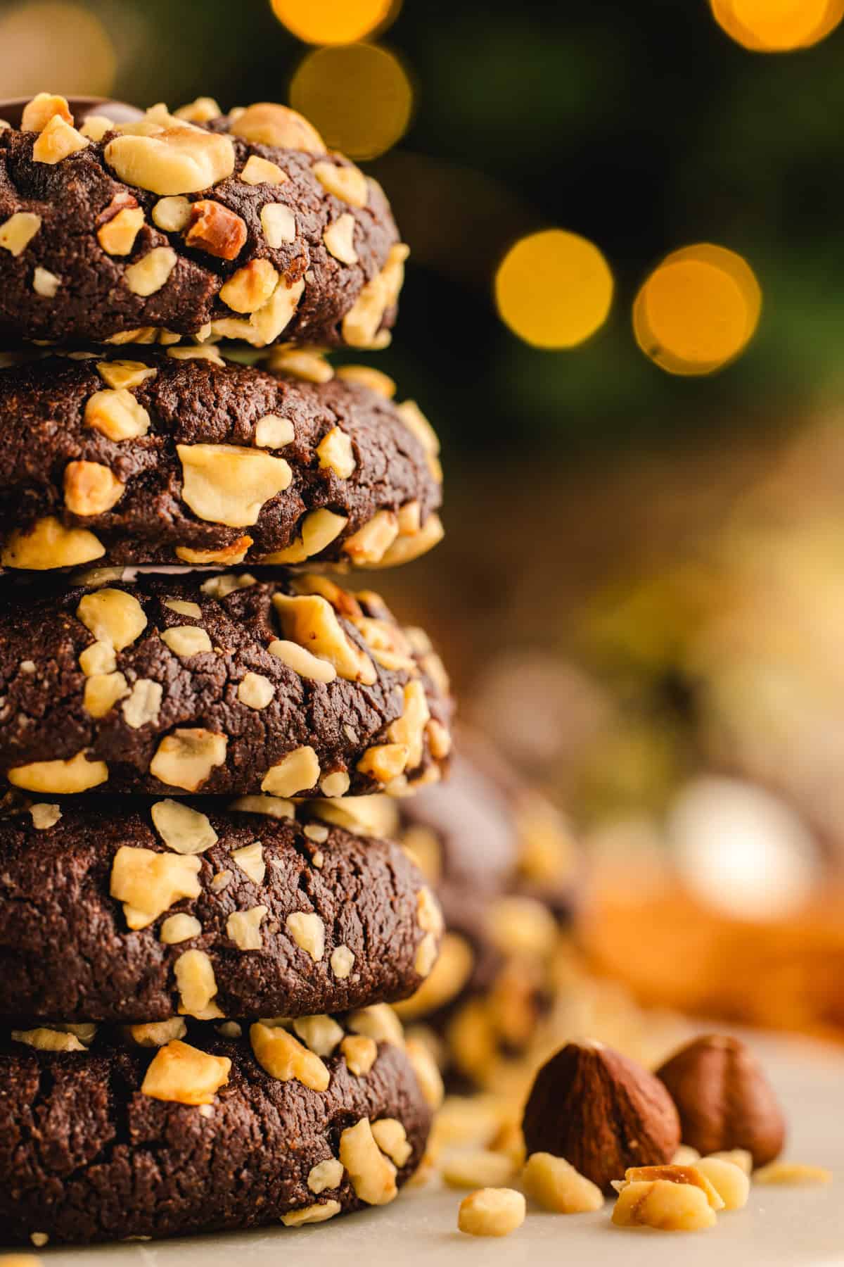 Chocolate Hazelnut Thumbprint Cookies A stack of 5 Chocolate Hazelnut Thumbprint Cookies with festive background.