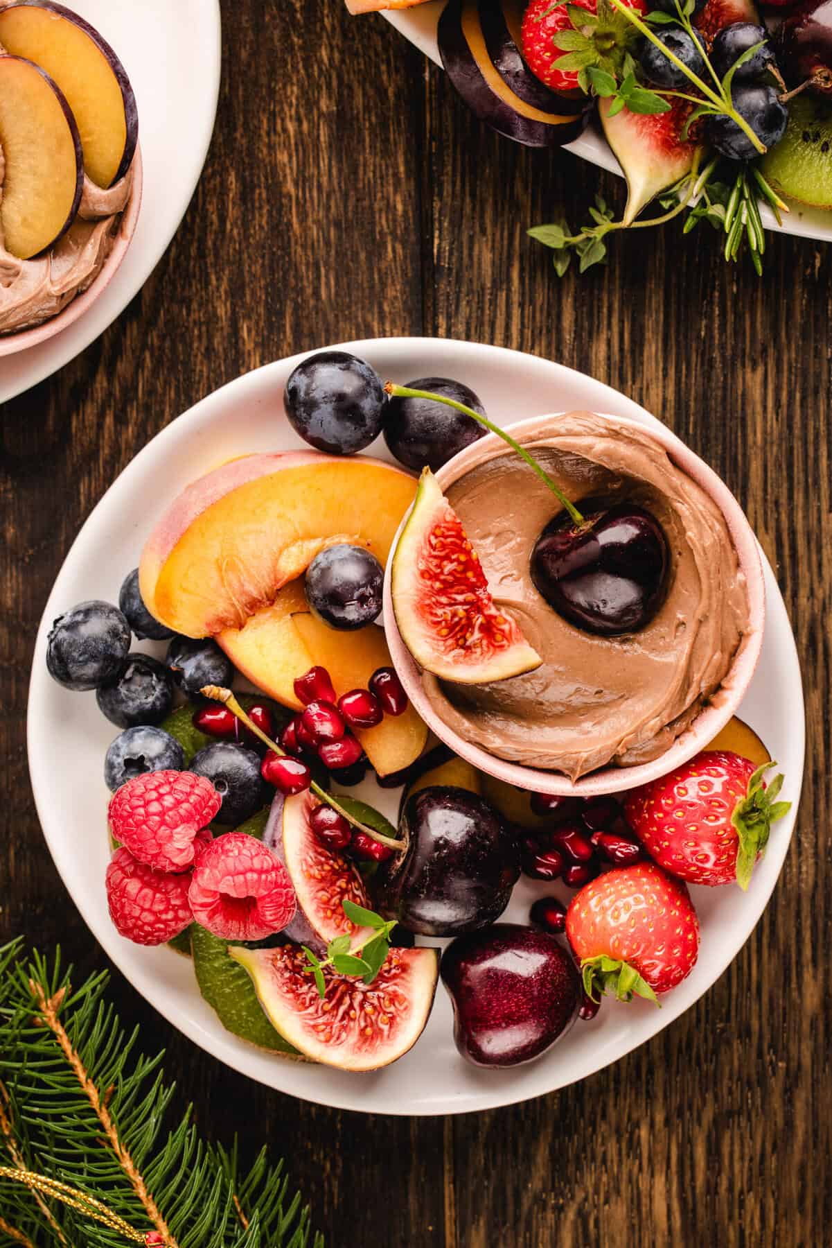 Fruit and Nutella Dip Assorted fruit on a small plate with the small bowl of Nutella dip.