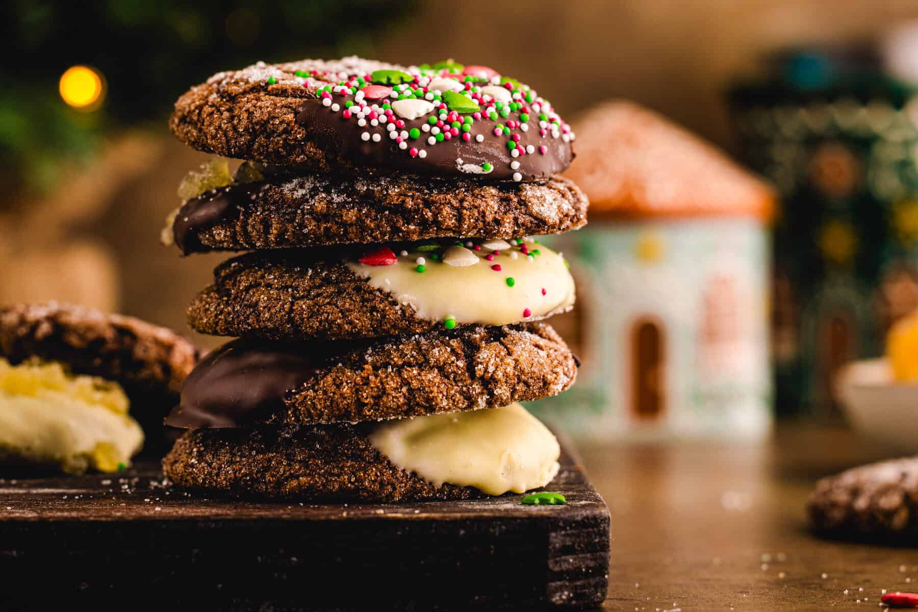 A stack of 5 ginger molasses cookies with Christmas decorations behind them.