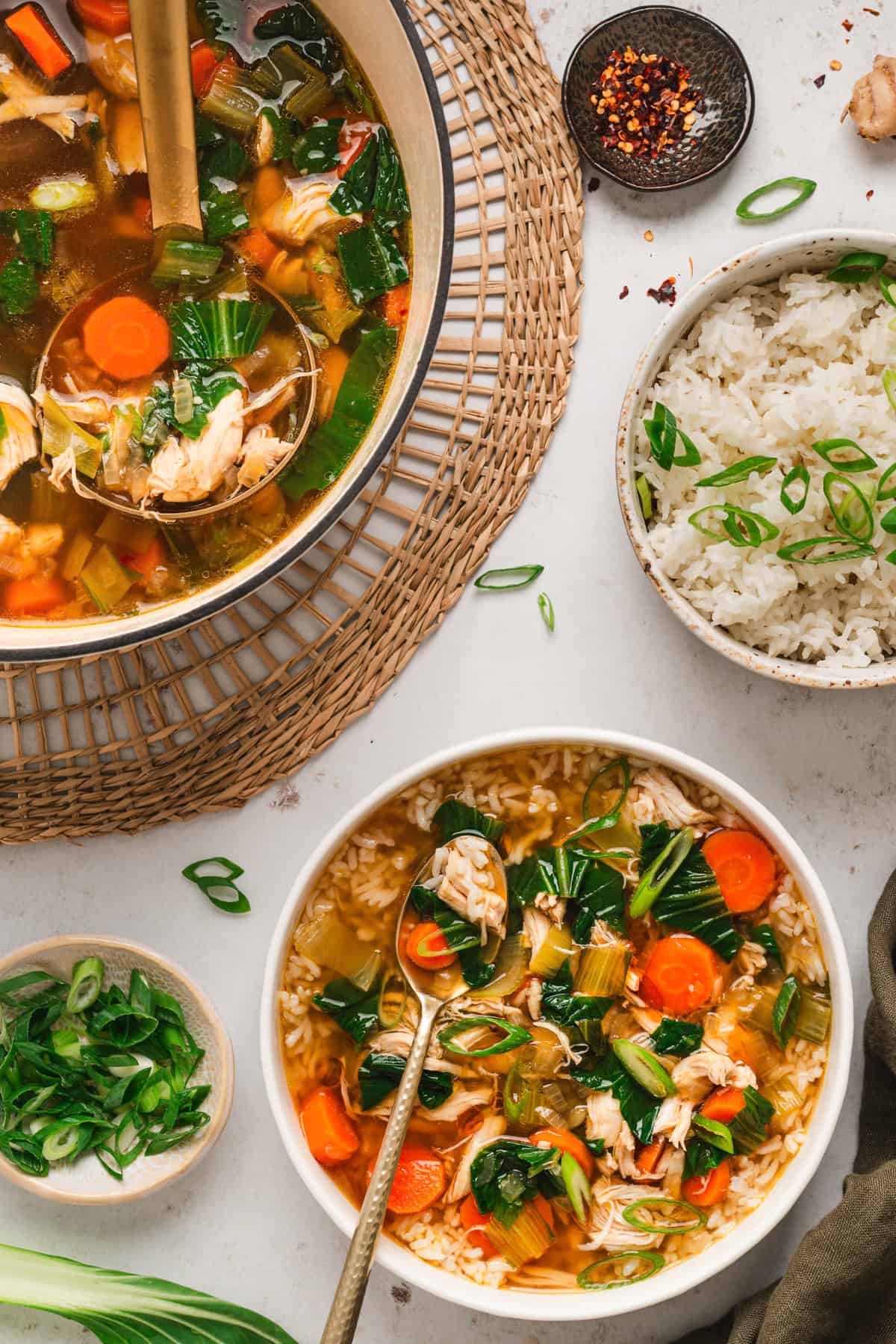 Asian Chicken and Rice Soup An overhead view of the bowl of Asian chicken and rice soup and partial view of the soup pot.