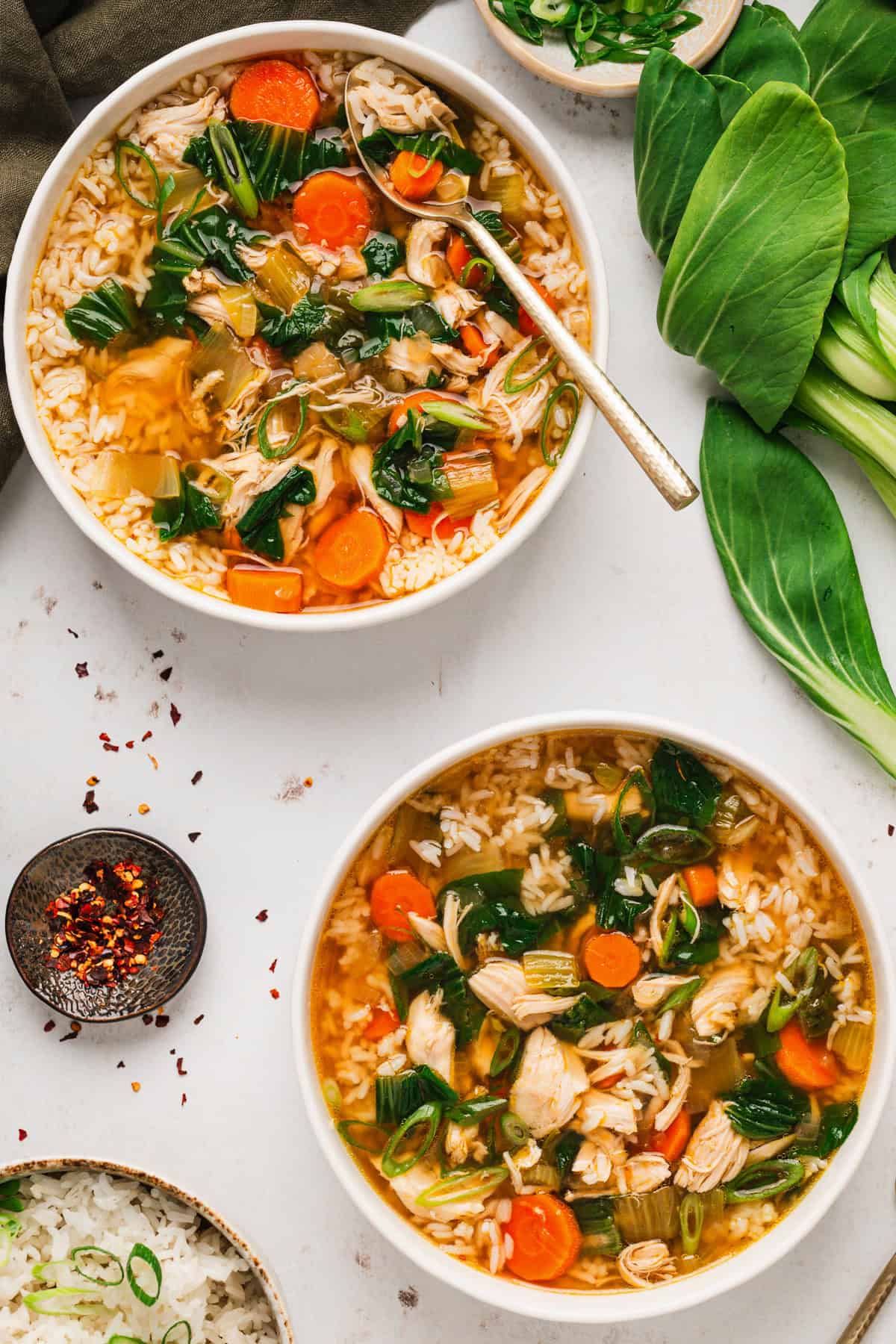 Asian Chicken and Rice Soup Two bowls of Asian Chicken and Rice Soup with Carrots, Bok Choy, and Rice (overhead view).