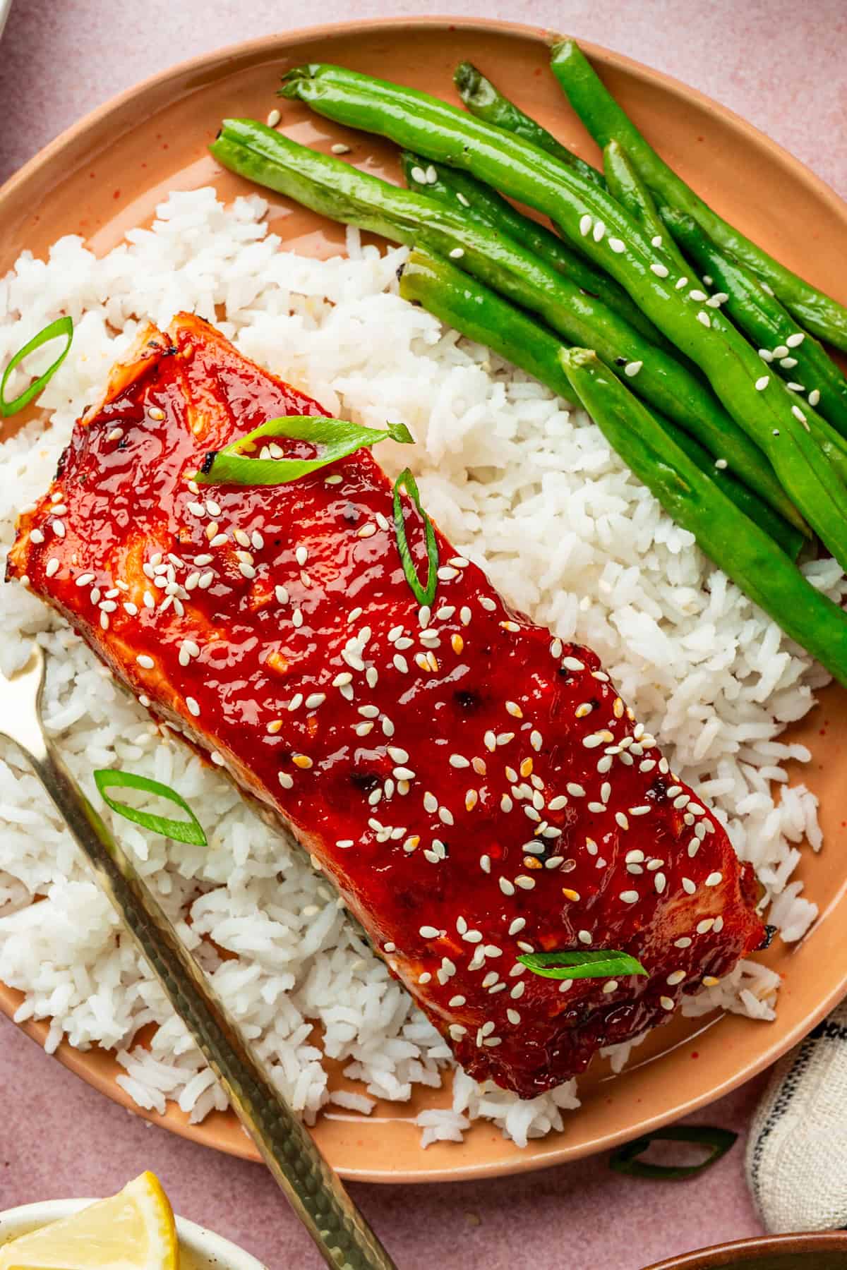 Vibrant Korean-style spicy gochujang glazed salmon served with fluffy rice and saut&eacute;ed green beans.