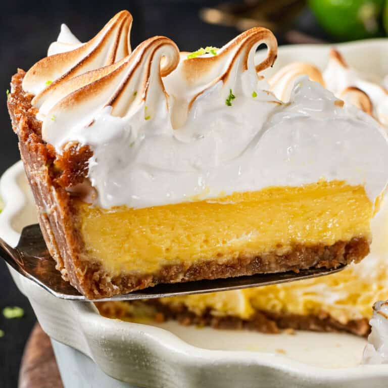 A slice of key lime pie with Swiss meringue - on a spatula.