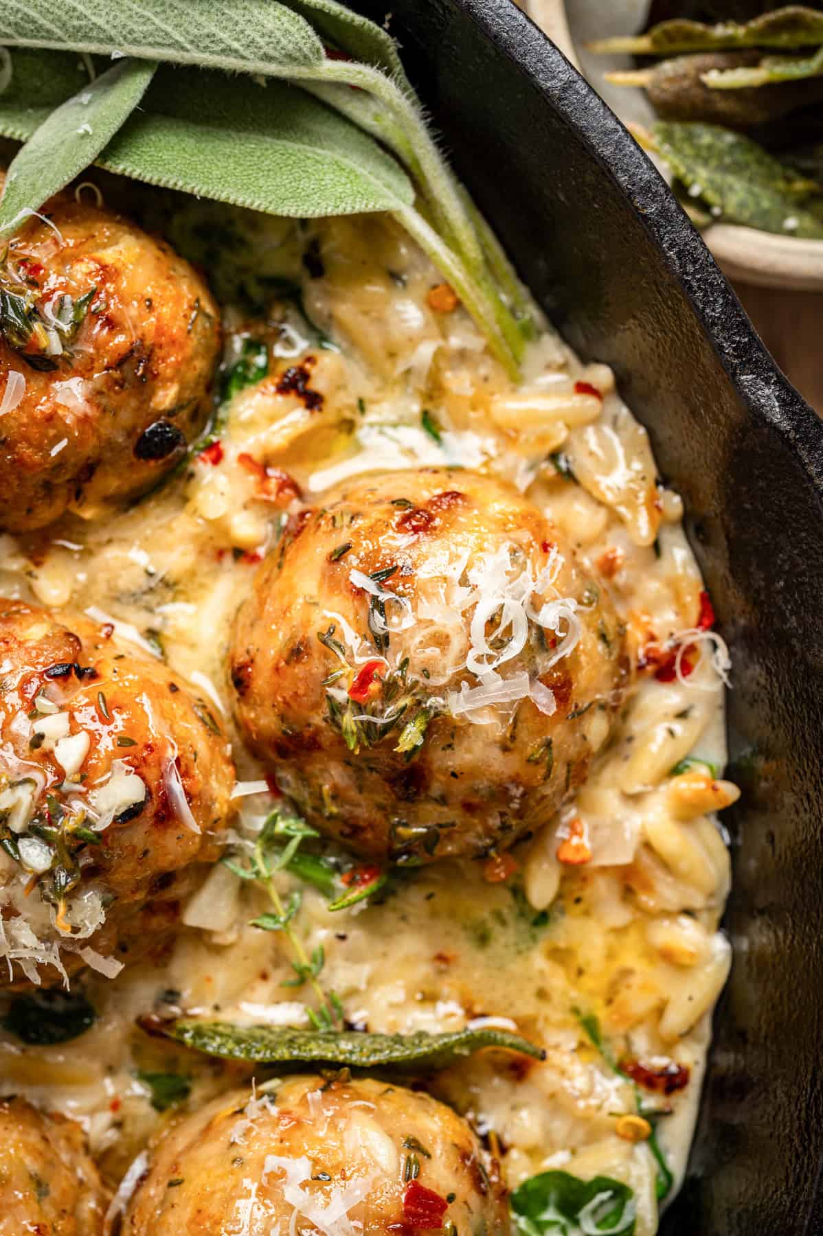 Oven-Baked Chicken Meatballs with Creamy Parmesan Spinach Orzo - in a cast iron skillet.