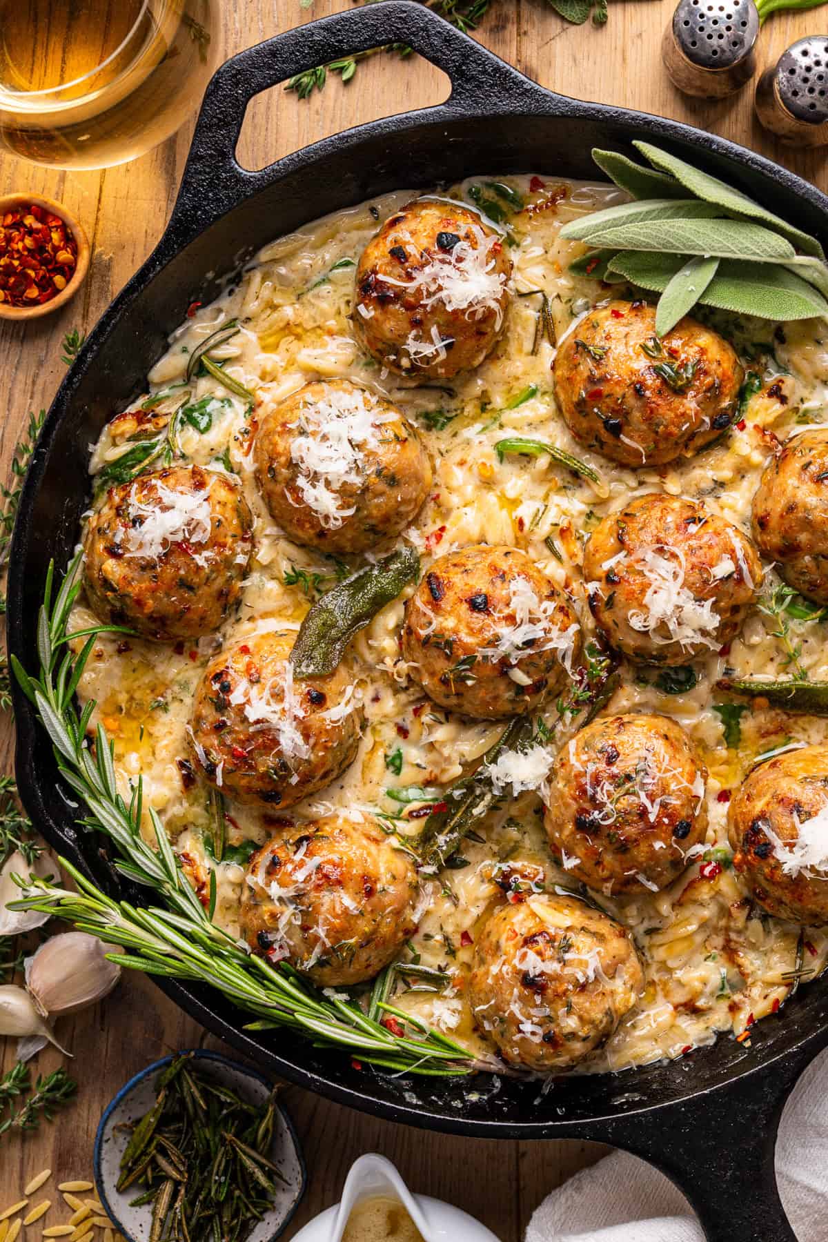 Oven-Baked Chicken Meatballs with Creamy Parmesan Spinach Orzo - in a cast iron skillet.