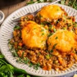 A portion of Shepherd’s Pie (topped with mashed potatoes tiled as "domes") - on a small white plate.