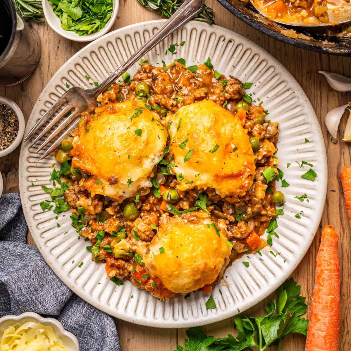A portion of Shepherd’s Pie (topped with mashed potatoes tiled as "domes") - on a small white plate.