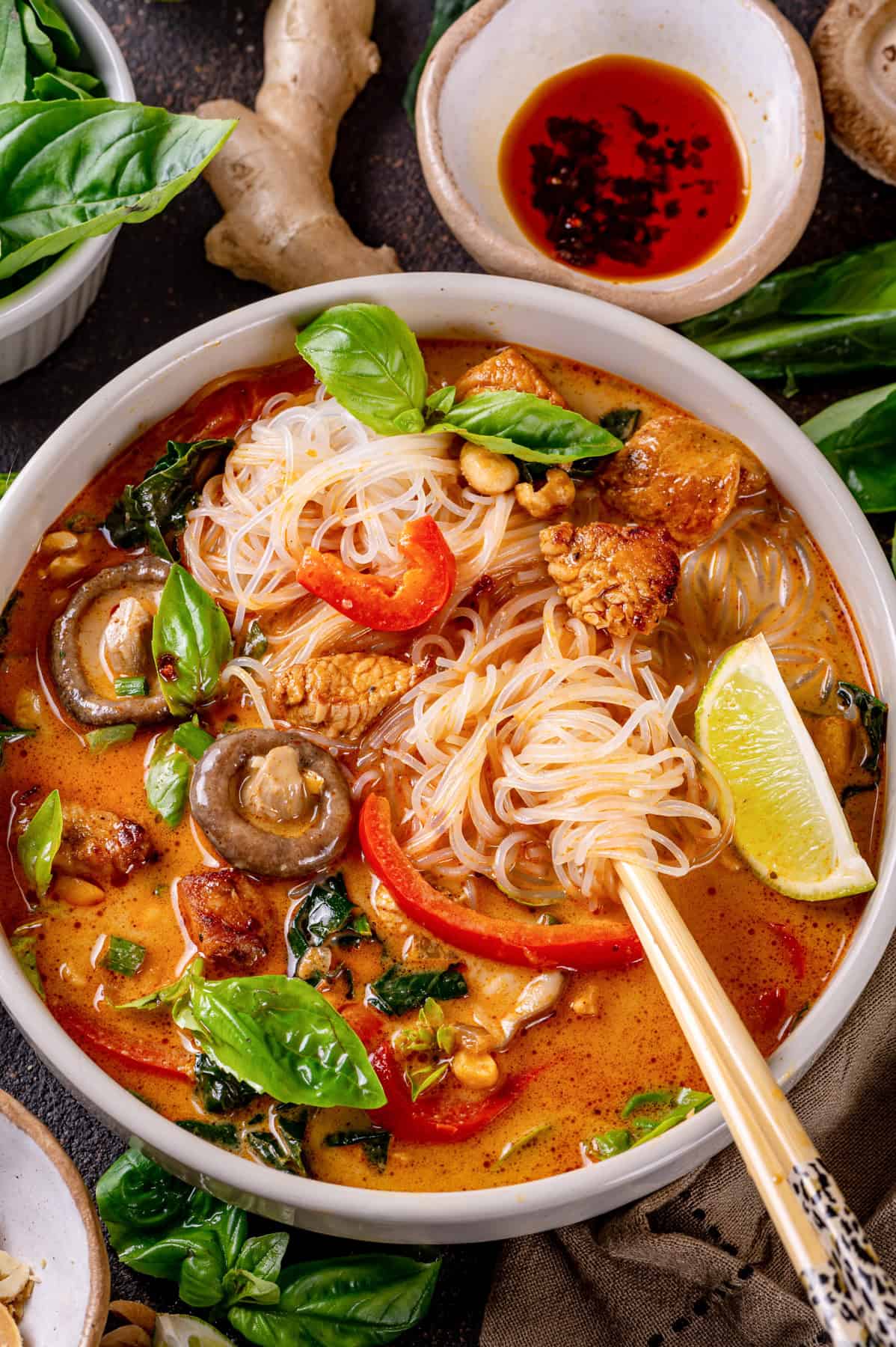 Thai chicken curry soup (with noodles, red bell peppers, and mushrooms) - in a bowl.