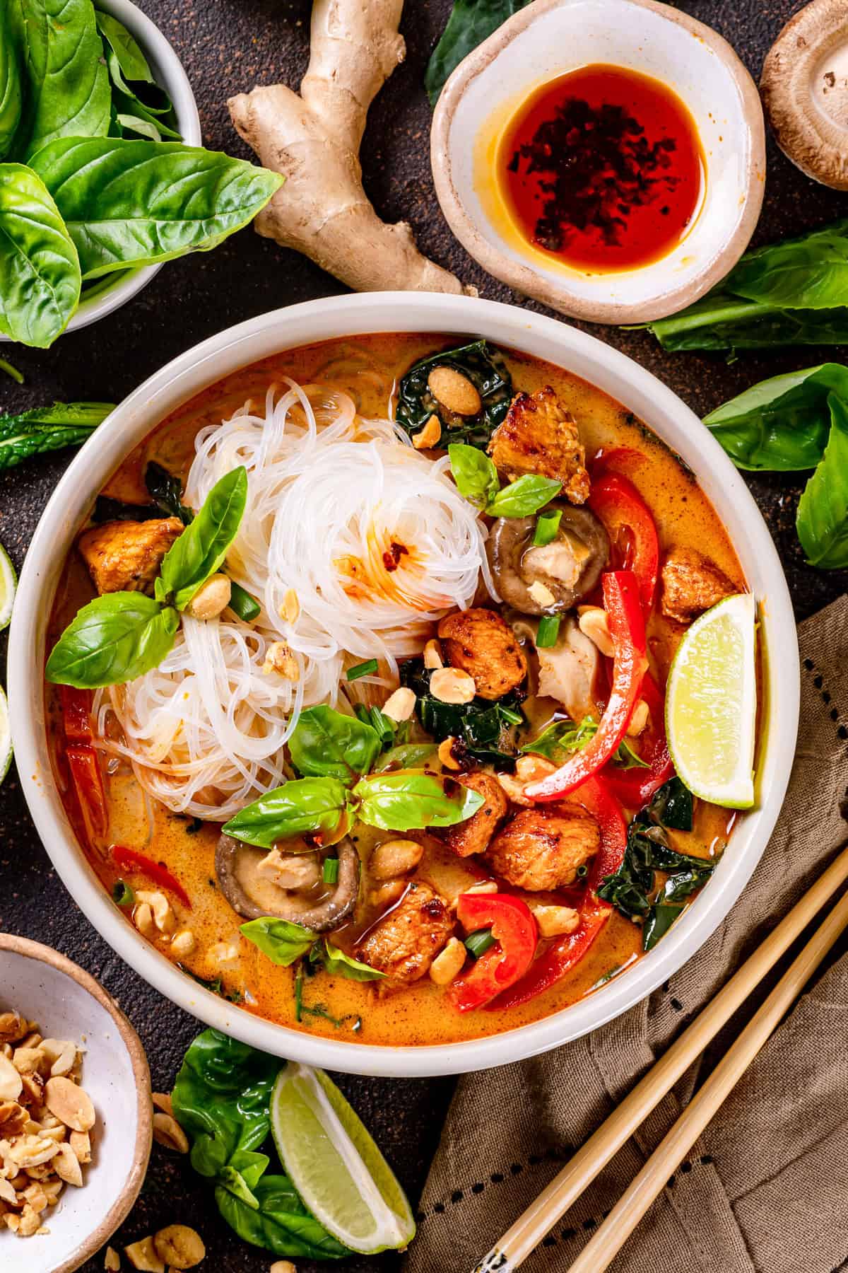 Thai chicken curry soup (with noodles, red bell peppers, and mushrooms) - in a bowl.
