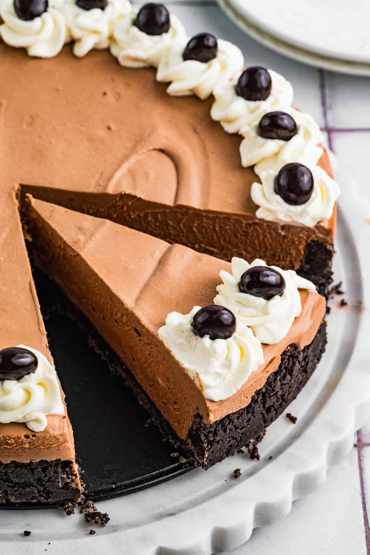 Mudslide Pie Mudslide Pie with a slice cut out. The pie has an Oreo cookie crust, chocolate filling, and is topped with swirls of whipped cream and dark chocolate-covered espresso beans.