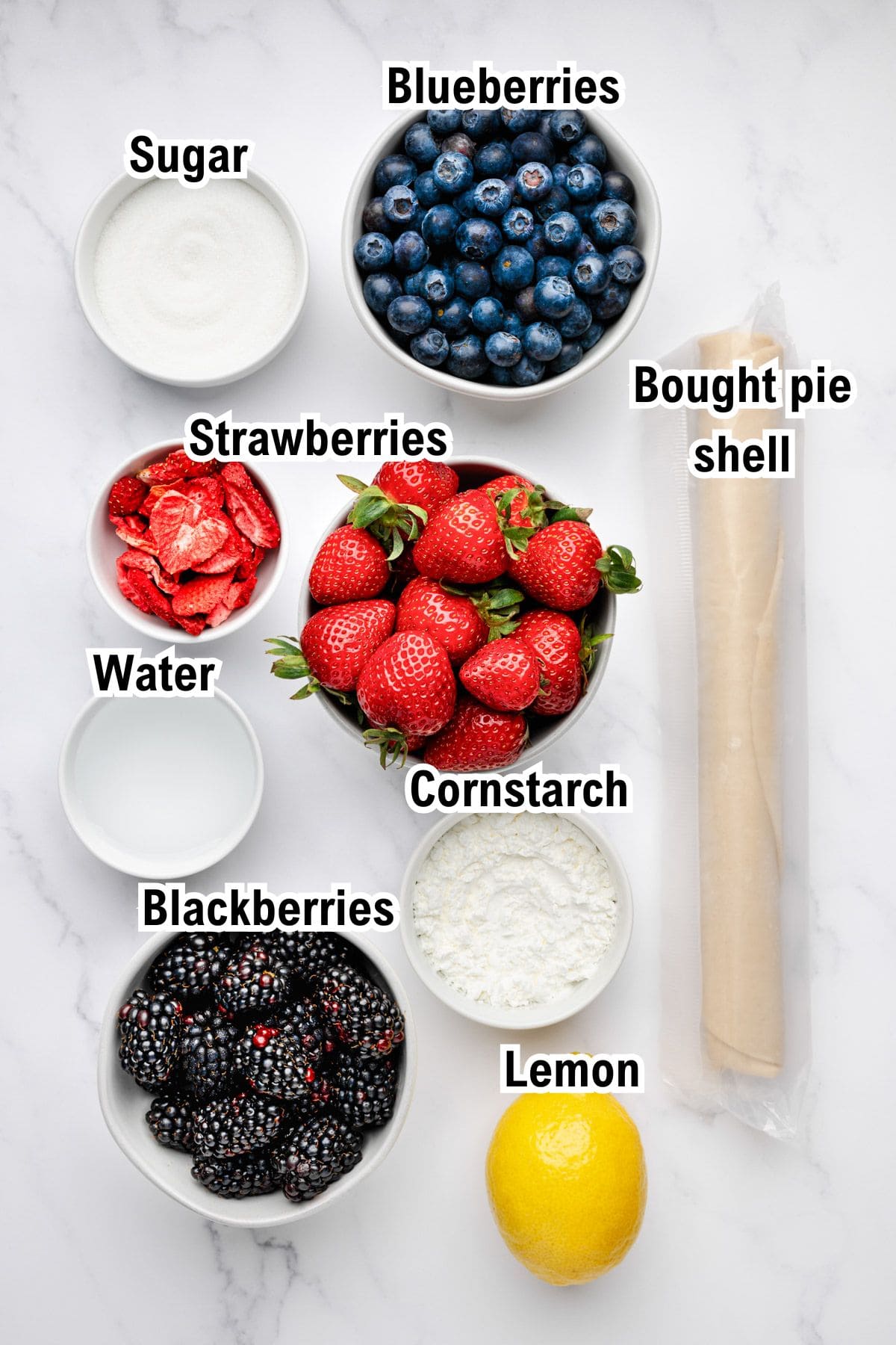 The Ingredients for Berry Pie This photo shows the ingredients for Berry Pie: Bowls of sugar, blueberries, strawberries, blackberries, cornstarch, and water, with a fresh lemon and a rolled bought pie shell.