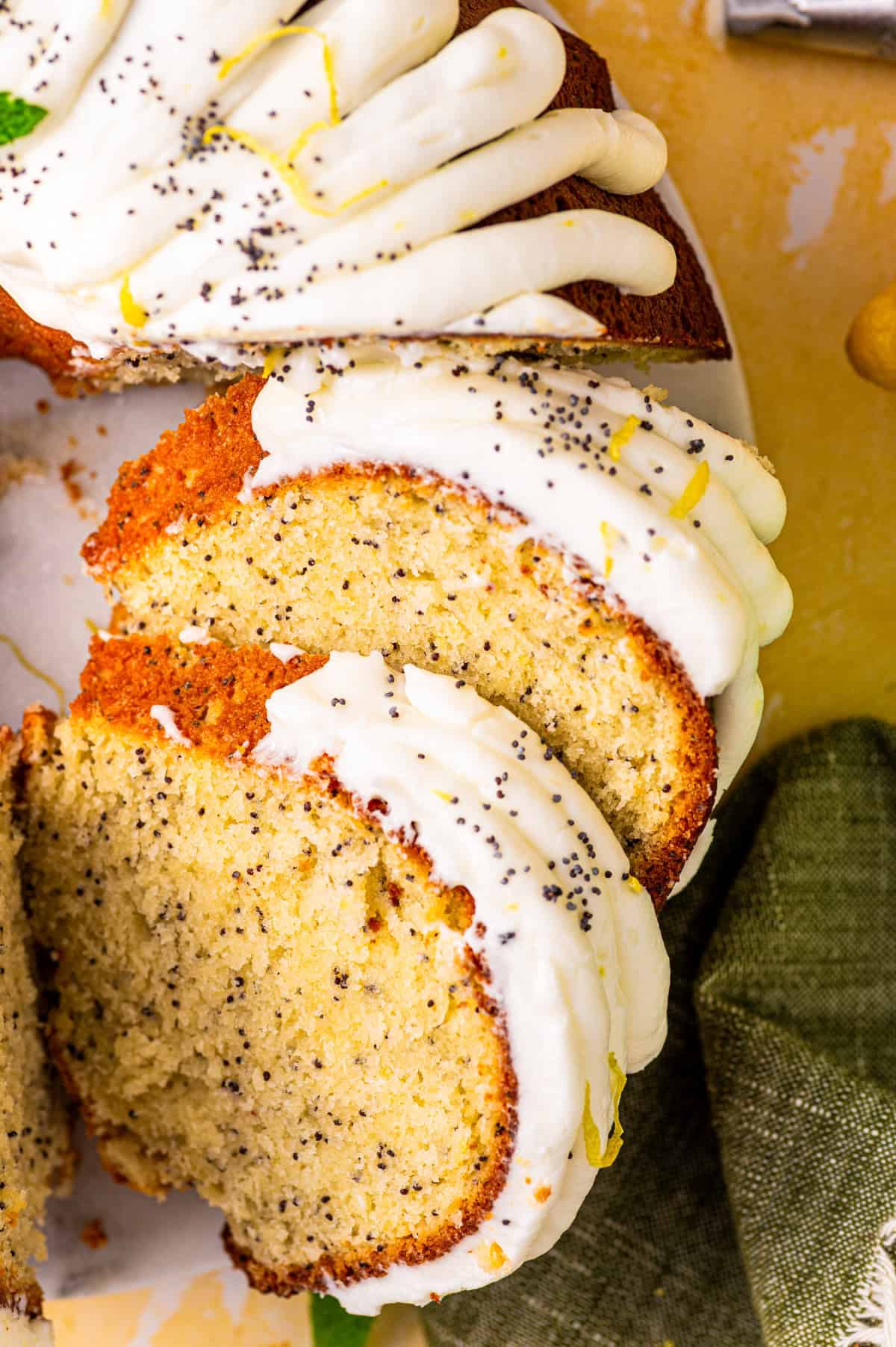 Poppy Seed Lemon Bundt Cake Two slices of bundt cake topped with white icing and sprinkled with poppy seeds.