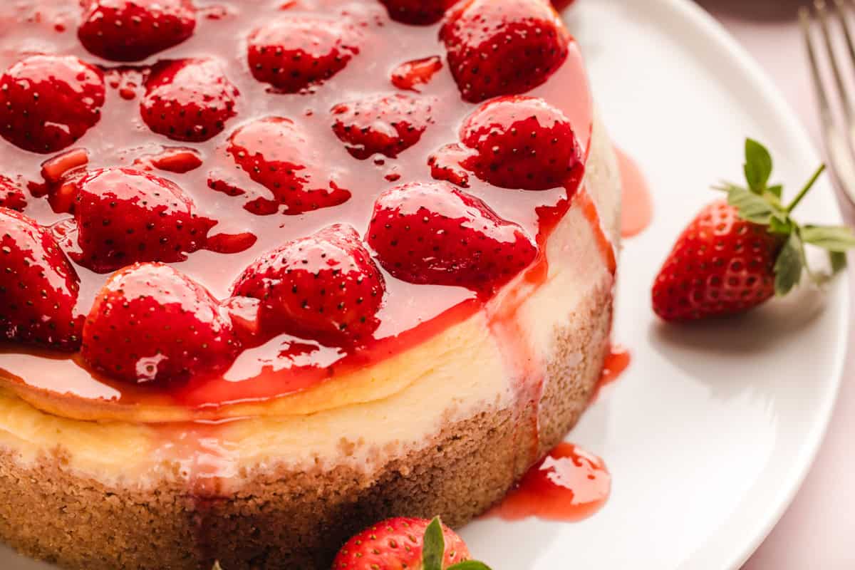 Classic New York-Style Cheesecake A close-up of a strawberry cheesecake topped with glazed strawberries.