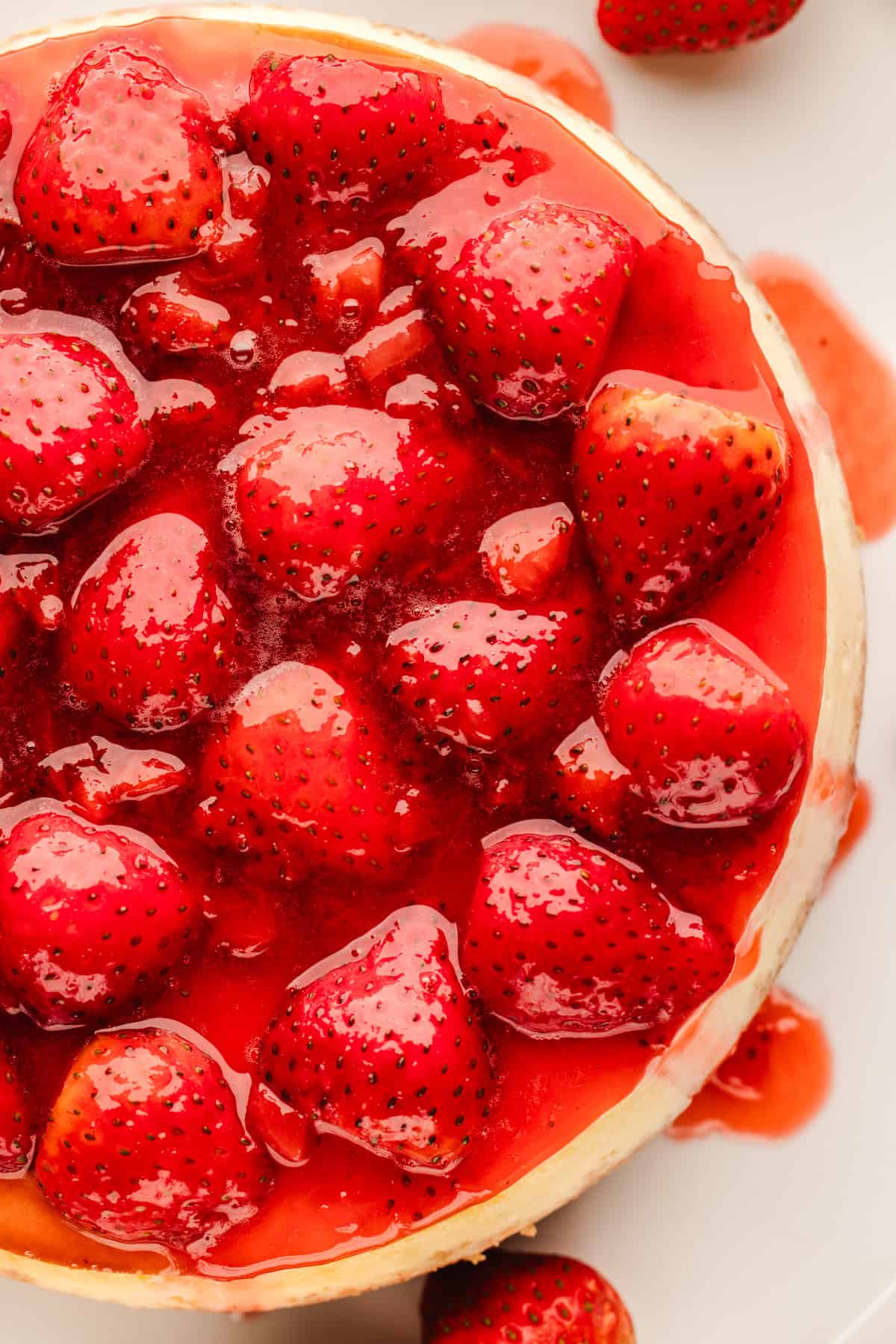 Classic New York-Style Cheesecake A close-up of a cheesecake topped with whole strawberries and a glossy strawberry glaze.