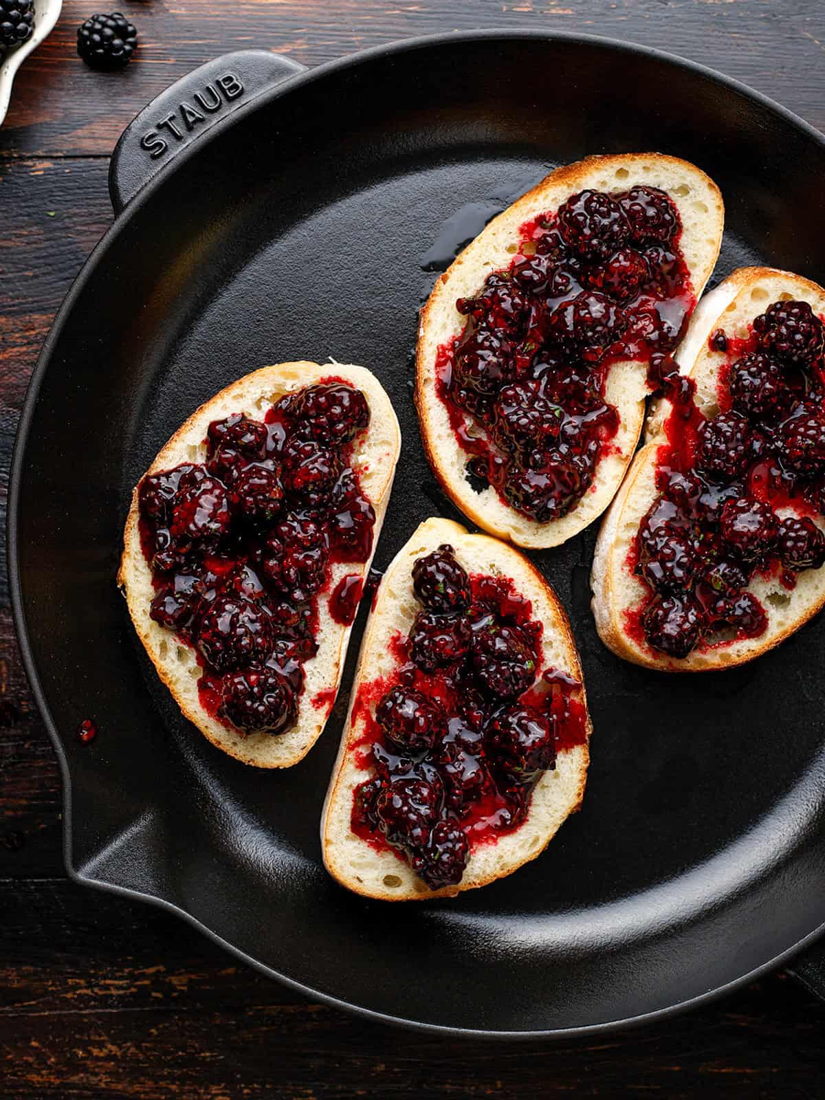 Four slices of bread topped with blackberry jam.