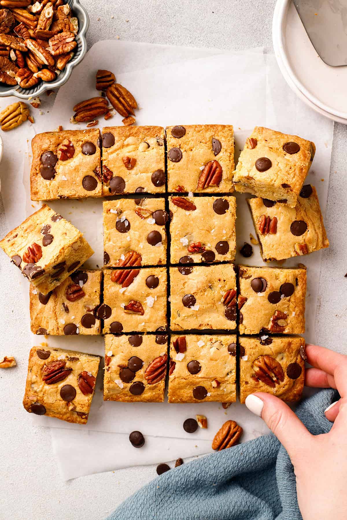 Blondies Blondie bars with chocolate chips and pecans on parchment paper, cut into squares.