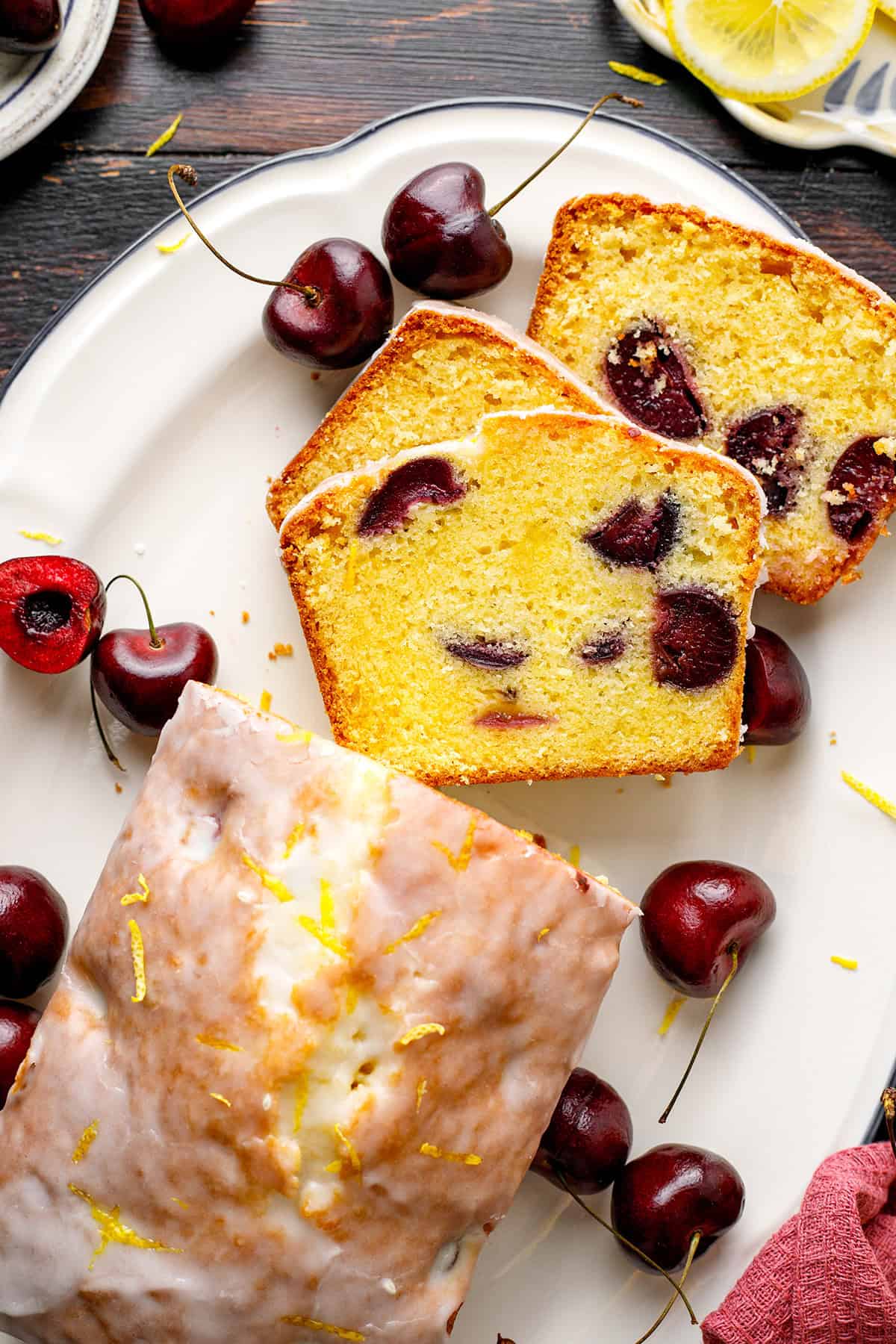Cherry Loaf Cake Loaf cake with cherries, sliced on a white plate.