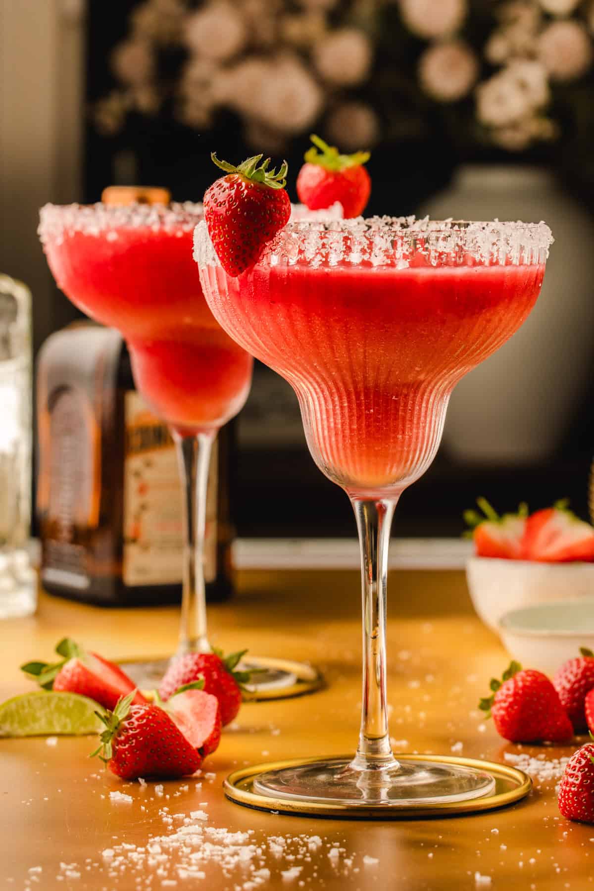 Strawberry Margarita Two strawberry margaritas in salt-rimmed glasses, each garnished with a whole strawberry.