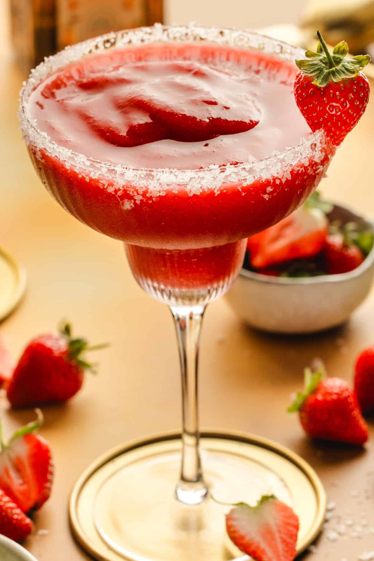 Strawberry Margarita A strawberry margarita in a glass with a salted rim, garnished with a whole strawberry.