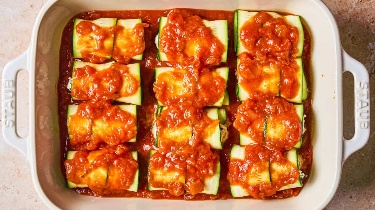 Zucchini Rollatini A baking dish filled with zucchini covered in tomato sauce.