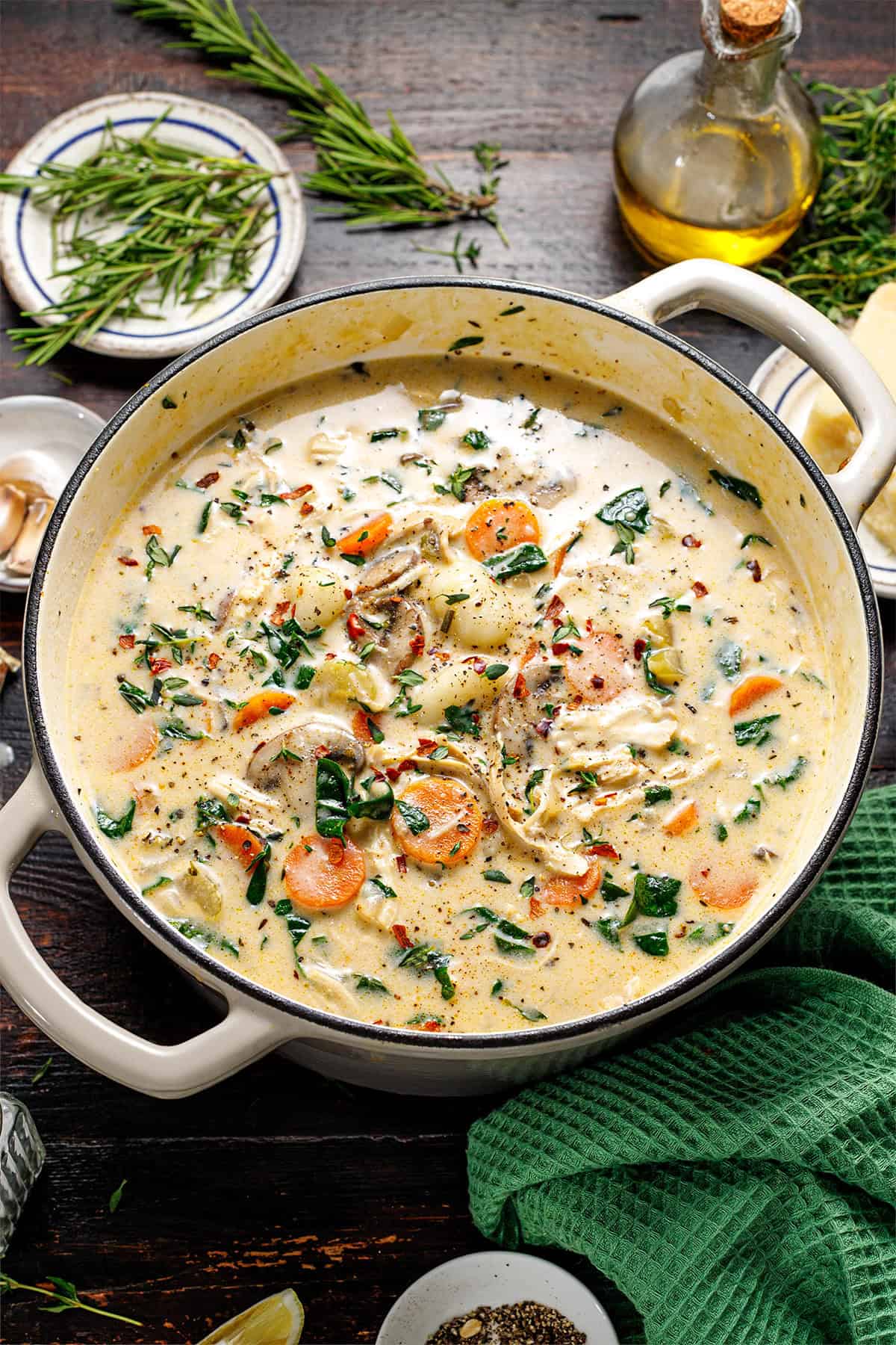 Chicken Gnocchi Soup A creamy soup with shredded chicken, carrots, spinach, and herbs in a white pot.