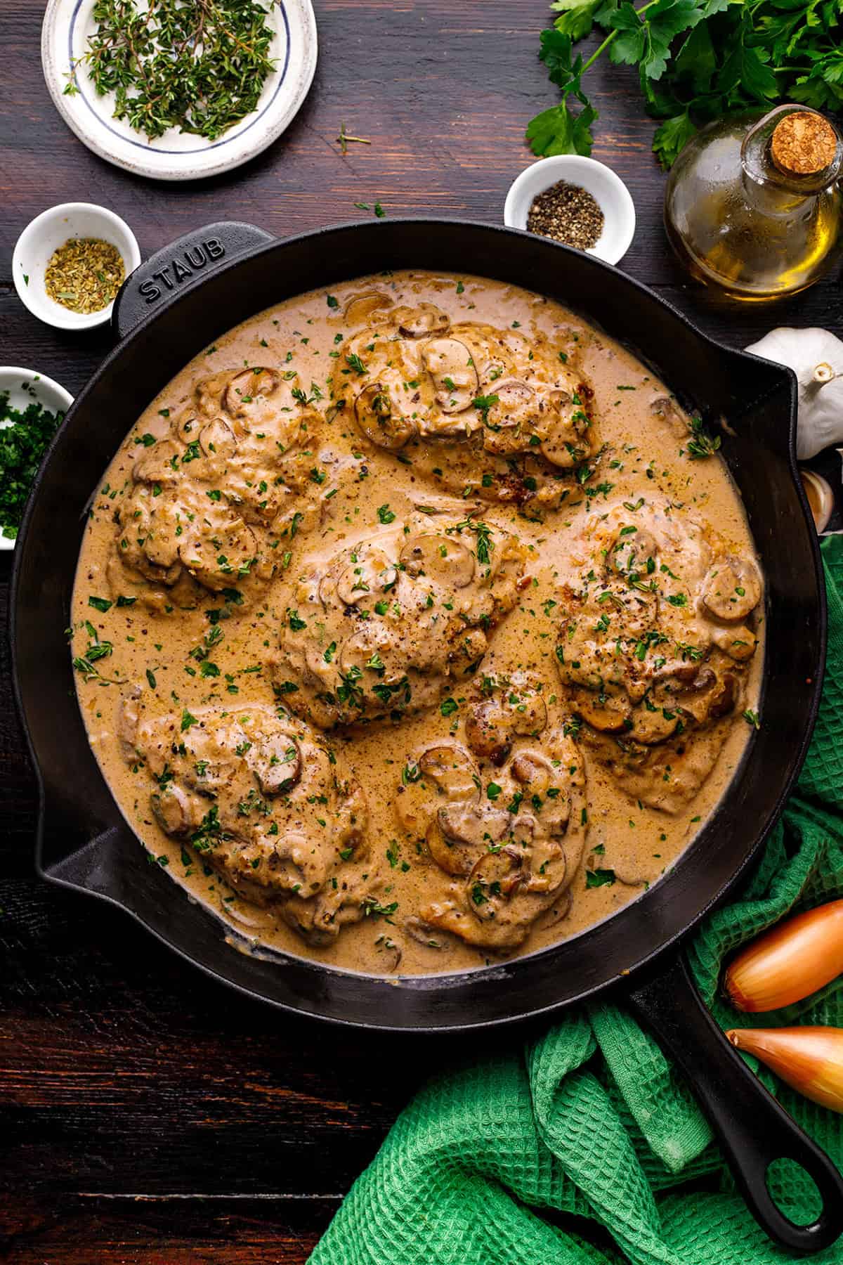 Chicken Marsala Chicken breasts in creamy mushroom sauce garnished with herbs, cooked in a black skillet.