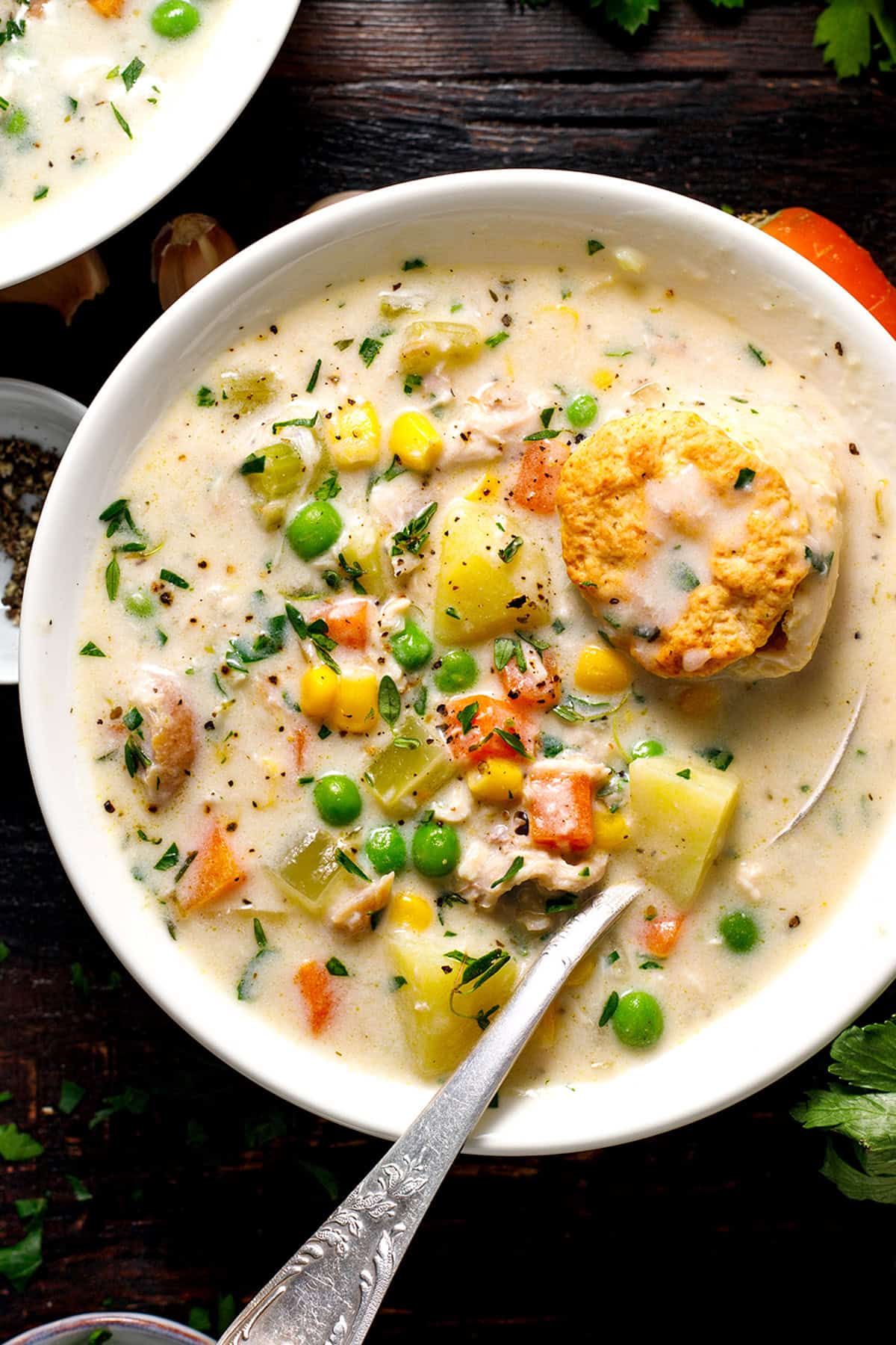 Chicken Pot Pie Soup A bowl of creamy vegetable soup with peas, corn, carrots, and potatoes, topped with a biscuit.