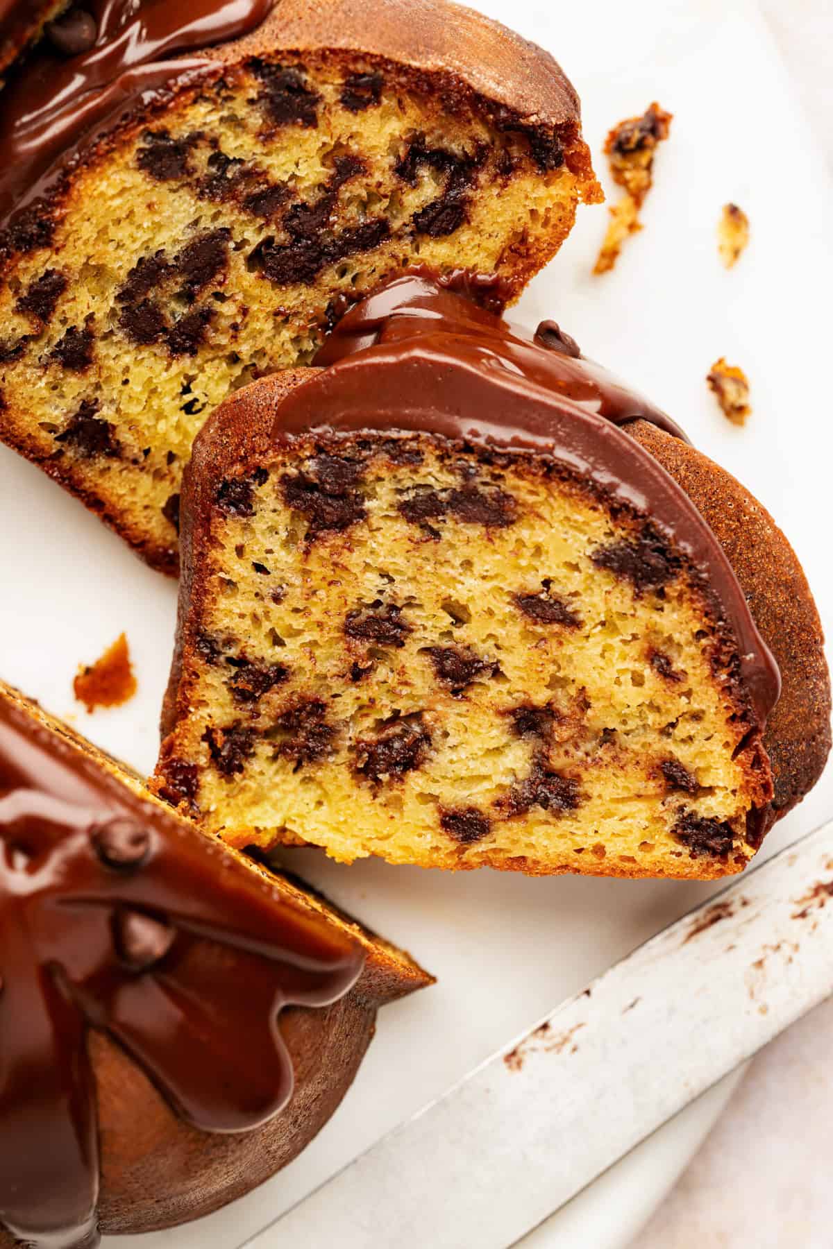 Two slices of chocolate chip bundt cake topped with glossy chocolate glaze.