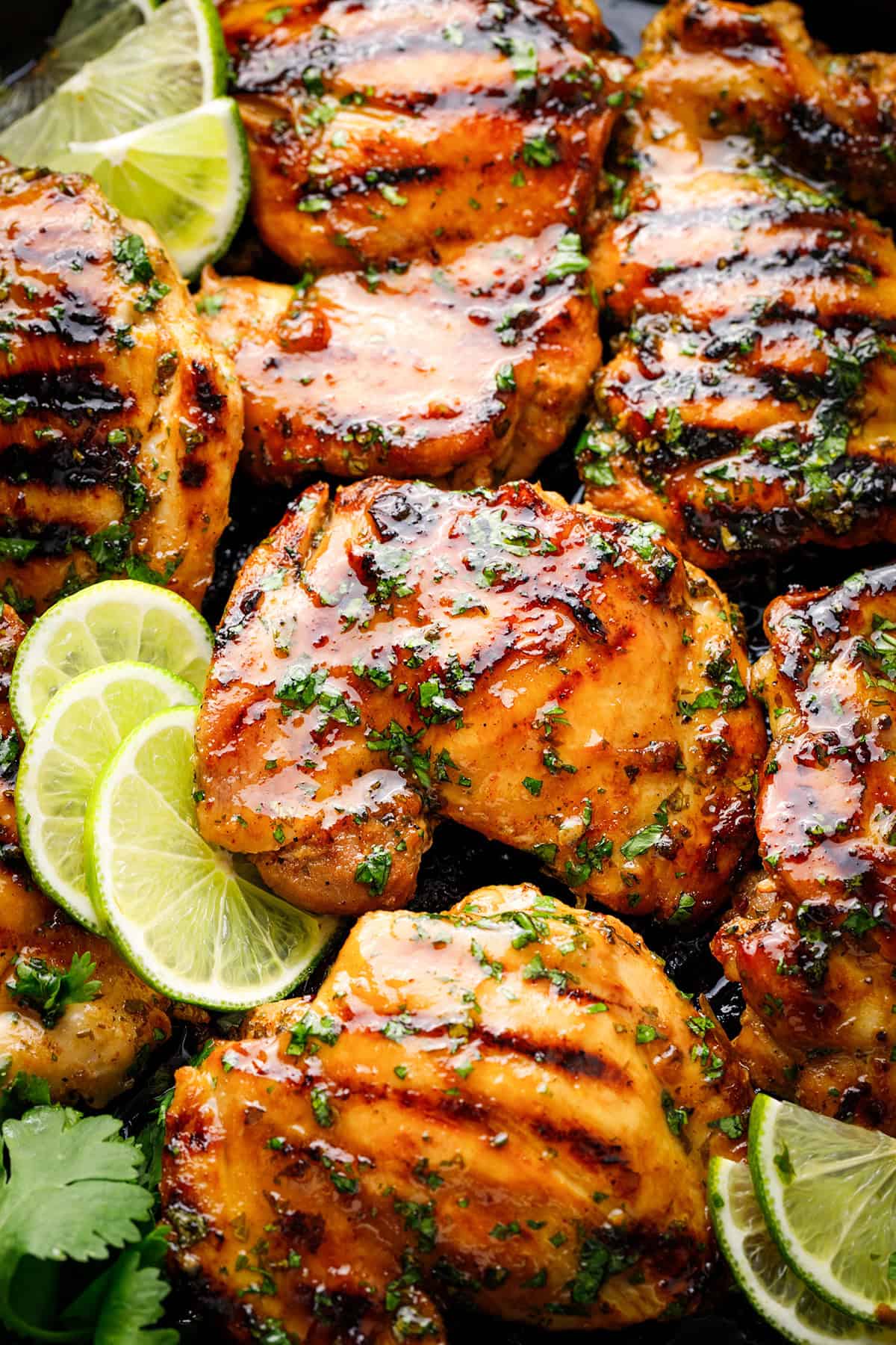 Grilled Cilantro Lime Chicken Thighs Grilled chicken thighs glazed with herbs, garnished with fresh cilantro and lime slices.