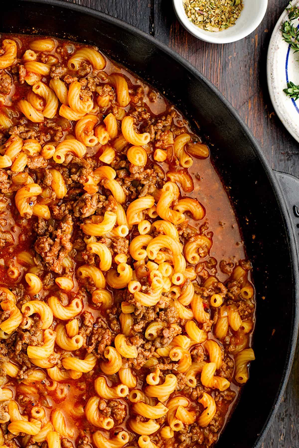 Hamburger Helper A skillet filled with cooked elbow macaroni mixed with ground beef in a tomato-based sauce.
