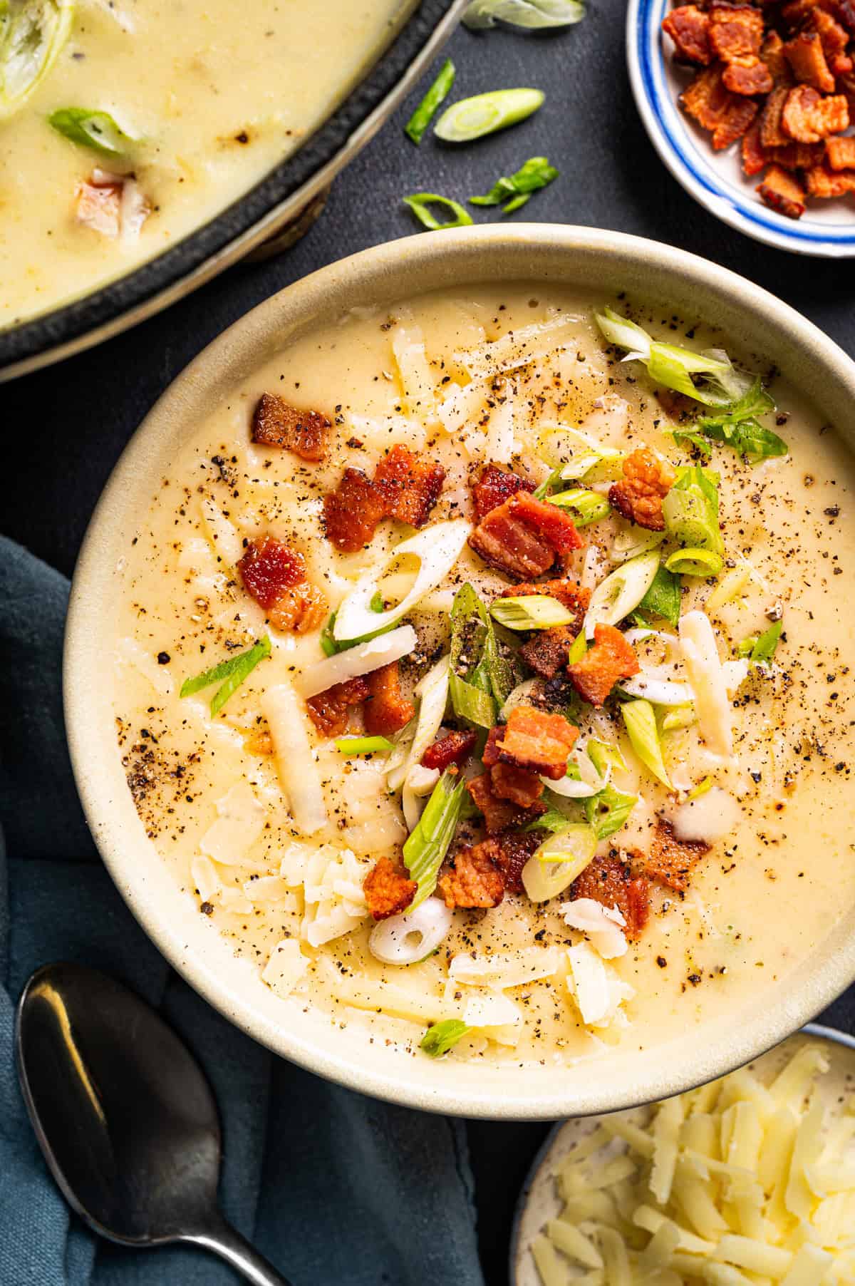 Creamy Potato Soup with Bacon and Cheddar A bowl of creamy potato soup topped with crispy bacon bits, shredded cheese, and sliced green onions.