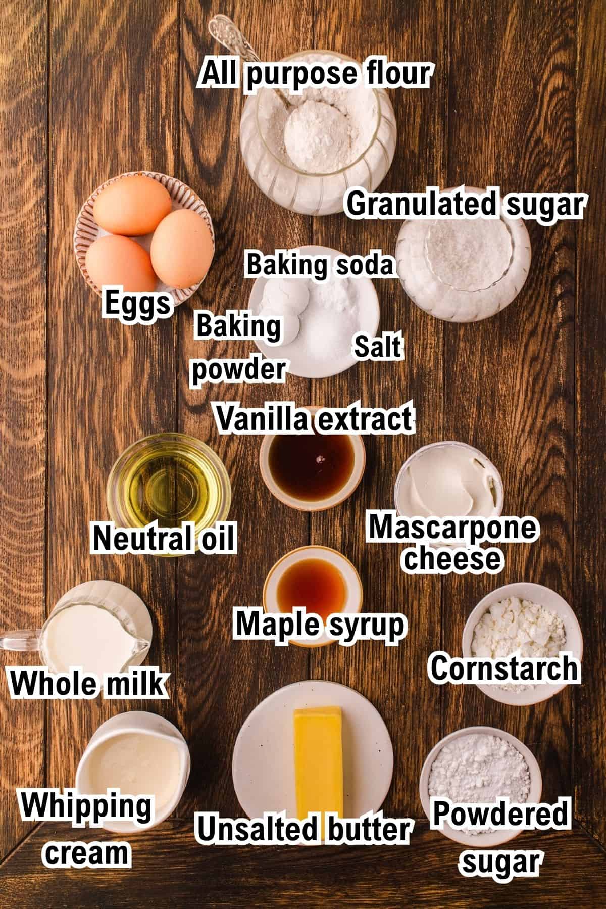 This photo shows the ingredients for Belgian Waffles, including eggs, flour, sugar, baking powder, soda, salt, vanilla, oil, mascarpone, cornstarch, milk, maple syrup, whipping cream, butter, and powdered sugar.