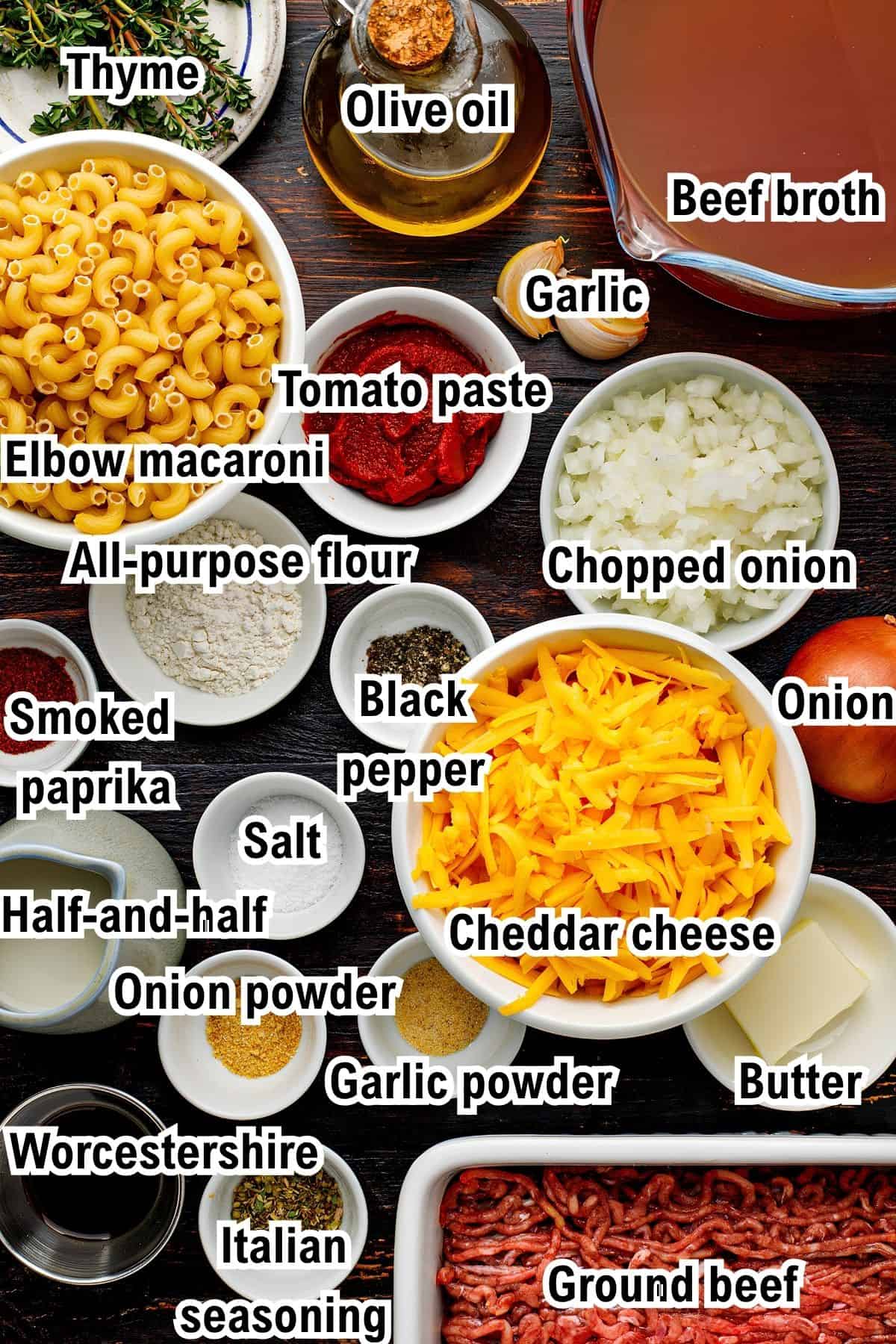 The Ingredients for Hamburger Helper This photo shows the ingredients for Hamburger Helper, including elbow macaroni, ground beef, cheddar cheese, beef broth, olive oil, onion, garlic, tomato paste, flour, half-and-half, butter, and various spices.
