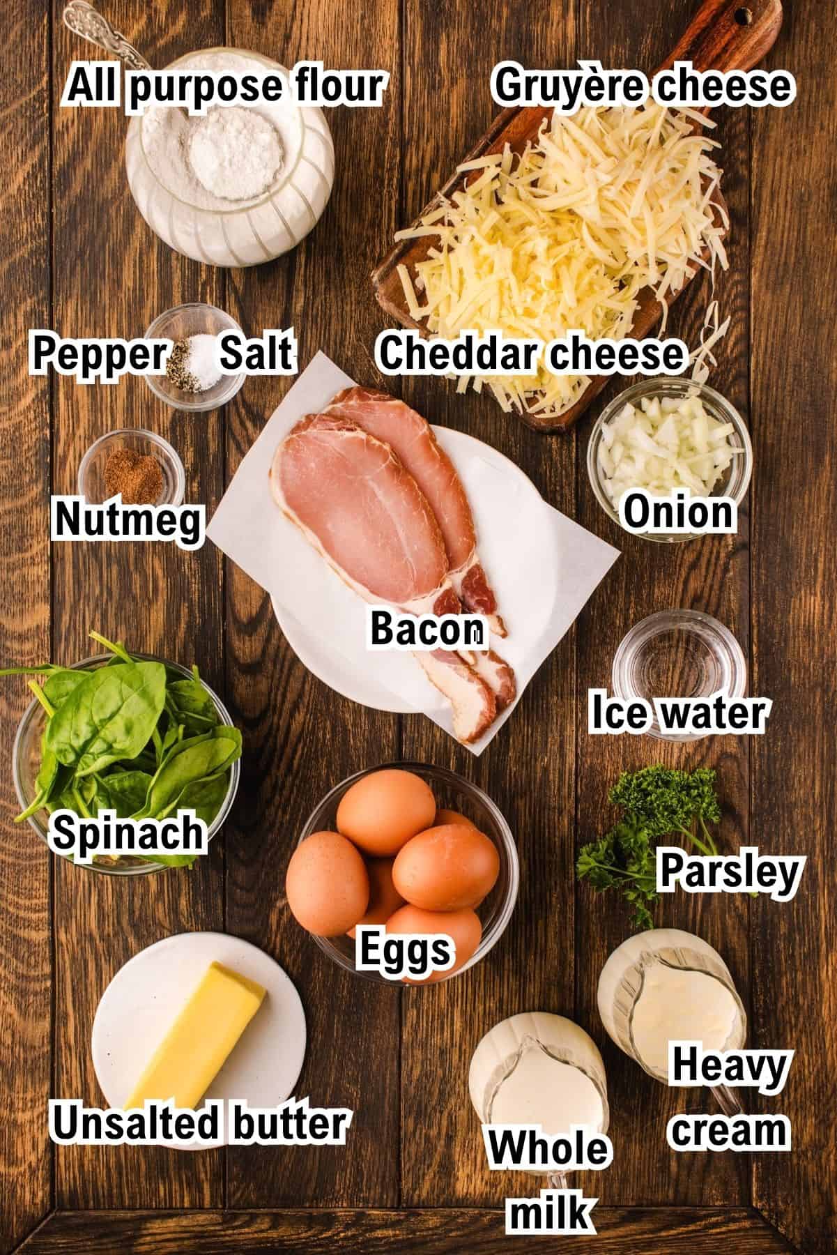 The Ingredients for Quiche This photo shows the quiche ingredients, including flour, Gruyère cheese, cheddar cheese, onion, ice water, parsley, heavy cream, milk, eggs, unsalted butter, spinach, nutmeg, pepper, salt, and a slice of bacon.