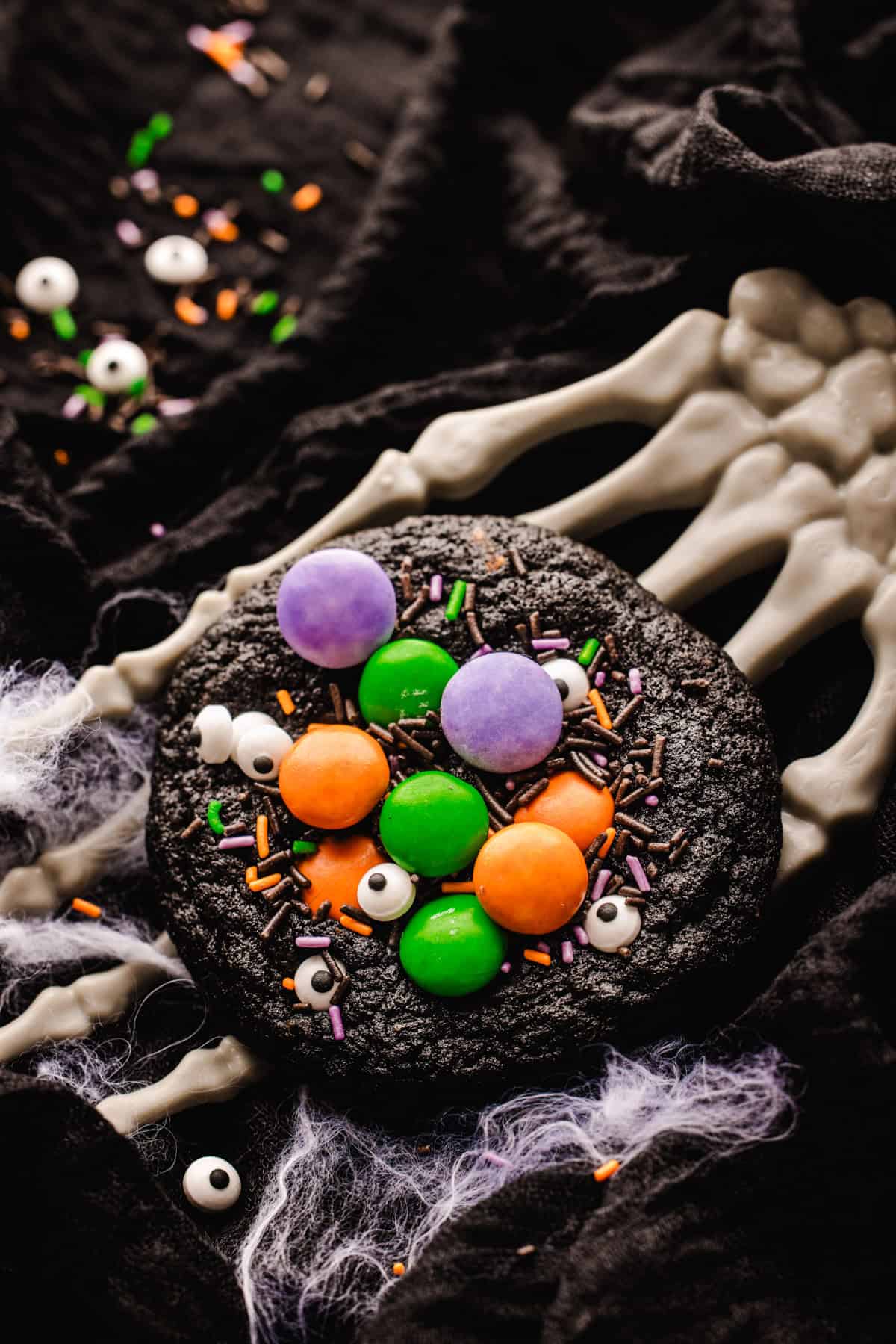 Halloween Cookies A dark chocolate cookie topped with candy eyeballs, colorful candy-coated chocolates, and sprinkles.