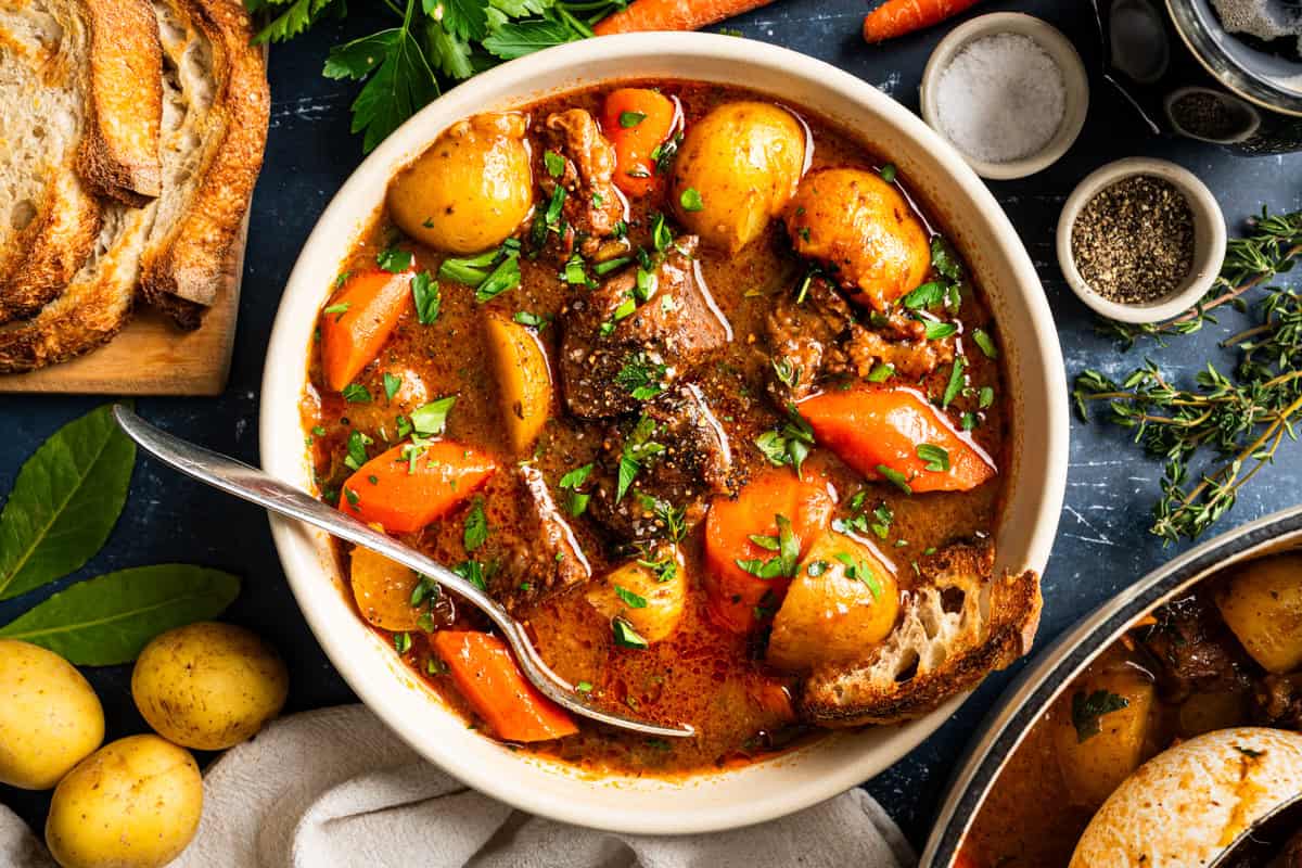 Irish Beef Stew A bowl of beef stew with potatoes and carrots, garnished with fresh herbs.