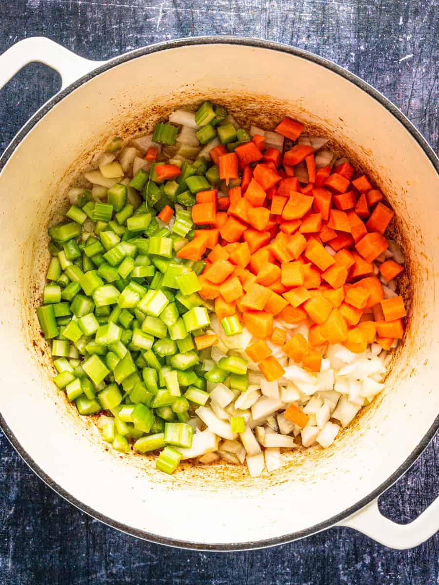 How to Make Corn Chowder (Step-By-Step Photos) Diced celery, carrots, and onions in a large white Dutch oven.