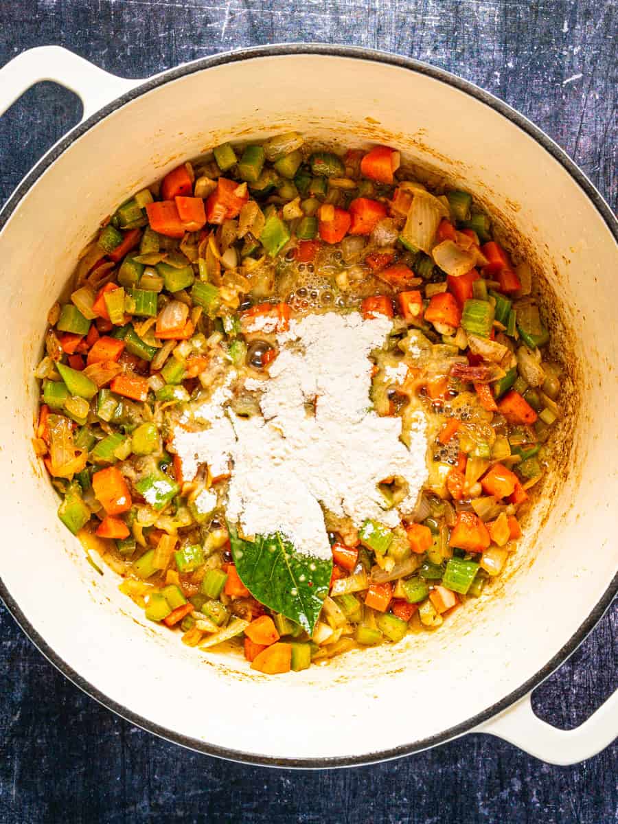 How to Make Corn Chowder (Step-By-Step Photos) Sautéed carrots, celery, and onions in a Dutch oven with a pile of flour and a bay leaf in the center.